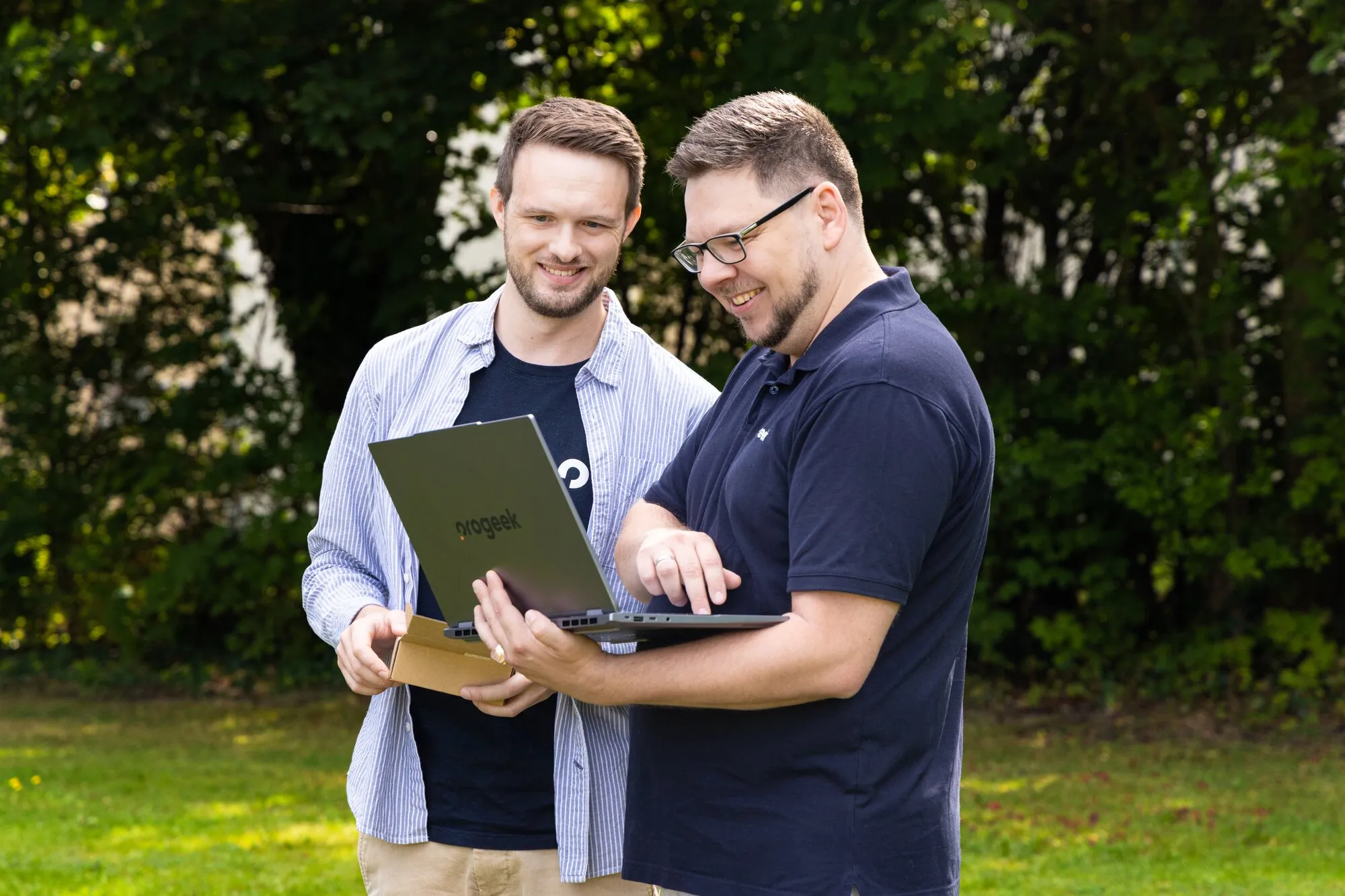 Zwei Personen sehen sich gemeinsam etwas auf einem Laptop an.